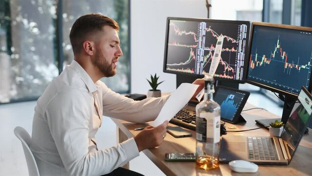 Using document, analyzing information. Stock broker in formal clothes is working indoors in the office