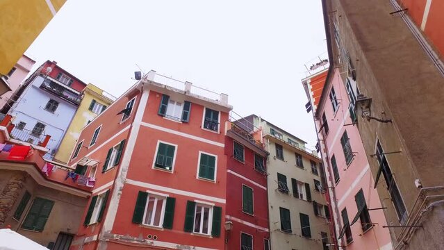 Walking through an ancient narrow street in Cinque Terre. Old town, architecture, color houses, narrow alleys in summer time.