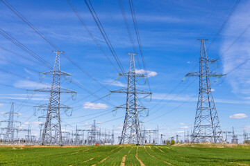High voltage electricity towers, transmission power lines, cables on transformers, and distribution substation