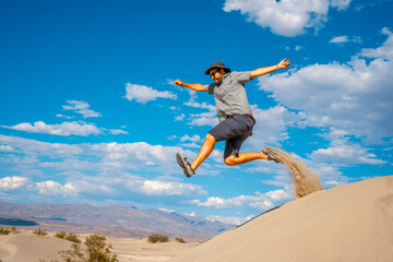 A young man jumping in desert on a summer afternoon in Death Valley, California