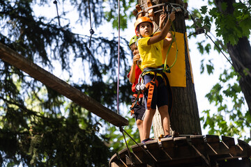 happy little girl in a rope park on the wood background