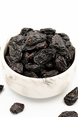 Black dried raisins on a white background. healthy and fresh.nuts. Close-up.