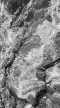 Desaturated fresh water in motion with reflections 