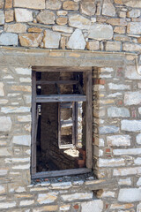 Fototapeta na wymiar The background old gray stony wall with a window