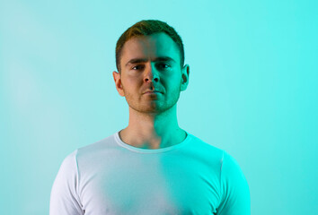 Contemporary young man posing in various poses in studio.Futuristic neon lighting.Portrait photo...