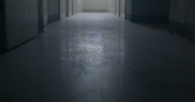 Night corridor, floor in a psychiatric hospital. The movement of the camera towards the light, a symbol of recovery. Lots of doors along the perimeter of the corridor.