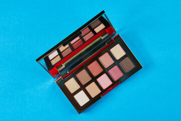 palette of multicolor eye shadows on a blue background