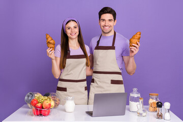 Photo of pretty sweet boyfriend girlfriend dressed chef outfits cooked tasty pastry gadget isolated purple color background