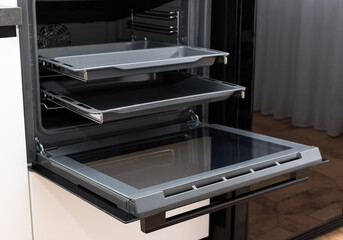 new electric oven built in with convention and trays on telescopic rails. Modern kitchen appliance.