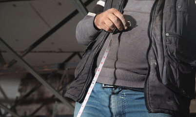 Caucasian worker holding measure tape.