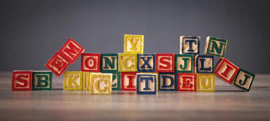 Colorful wooden cubes with letters on the wooden table.