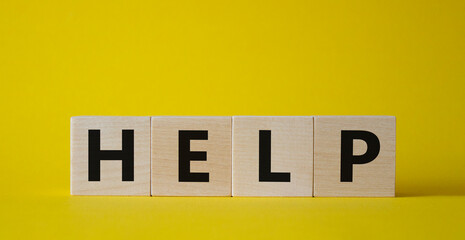 Help symbol. Concept word help on wooden cubes. Beautiful yellow background. Business and help concept. Copy space.