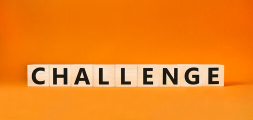 Challenge symbol. Concept words challenge on wooden cubes. Beautiful orange background. Business and challenge concept. Copy space.