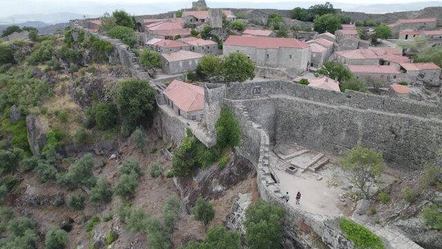 Ramparts surrounding historical village of Sortelha, Portugal; aerial pan