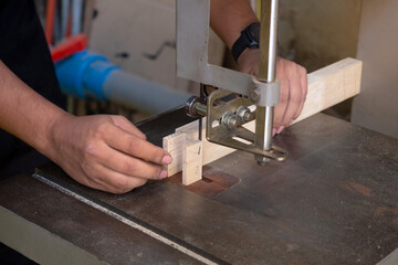 Carpenter using a circular saw to cut a part of wood. Carpenters, tools, construction concept. Close-up.