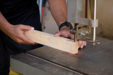 Close-up of a carpenter using a jigsaw to cut a board of wood. Construction concept.
