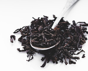 dried black tea on a white acrylic background