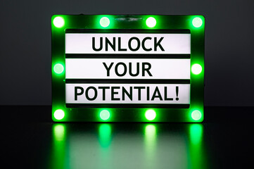 Lightbox with green lights in dark room with words - unlock your potential!