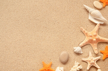 Fototapeta na wymiar Sea sand with starfish and shells. Top view with copy space.