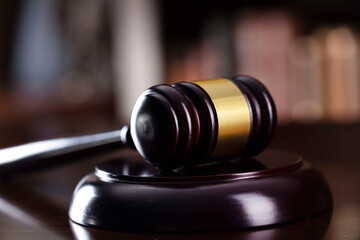 Judge office. Gavel on the judge desk. Book shelf in the background.