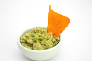 Guacamole dip and nachos chips on white background