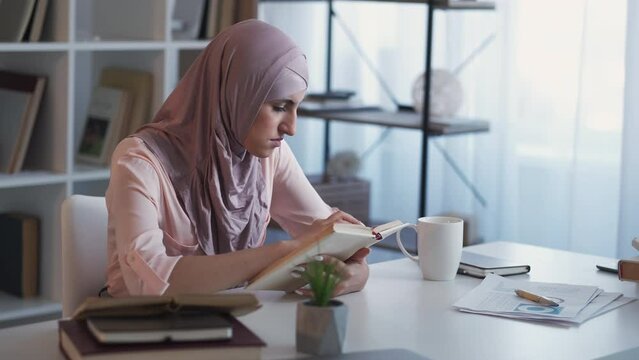 Intern education. Book study. Work research. Diligent woman student reading statistics course learning lesson at home office workplace.