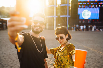 Couple at music festival. Young friends drinking beer and having fun at music festival together....