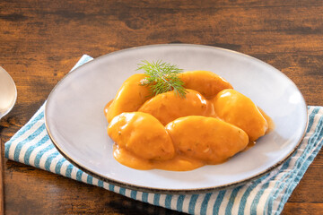 dumplings with tomato sauce in a white plate on a table