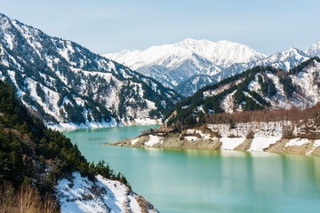 Fototapeta na wymiar 黒部のダム湖から見る雪の残る風景