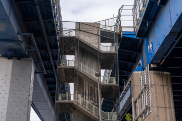 Grey zigzag stairs between two bridges, architecture and structure concept, front view, old stair,...