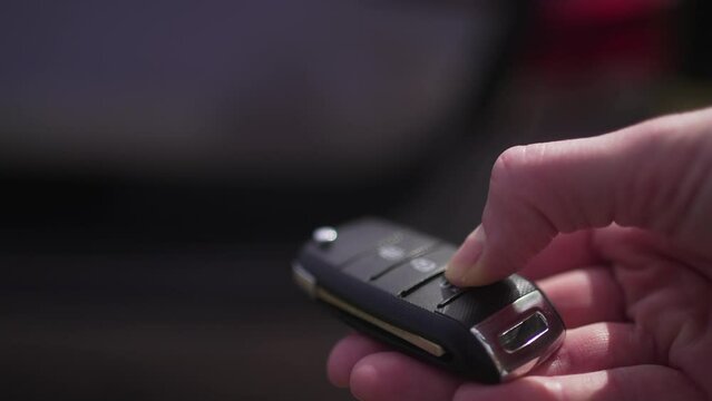 Person opens the trunk of the car with a remote access key. Close-up. Travel by car, logistics 4K 10 BIT