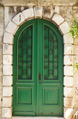 Green old textured door in a stone wall, Rovinj, Croatia, Europe 