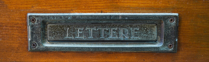 Postal mail slot on wooden surface 
