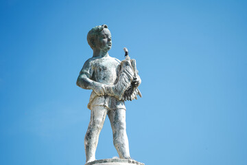 Boy with the fish Fountain on Main Square in Rovinj, Croatia with blue sky background
