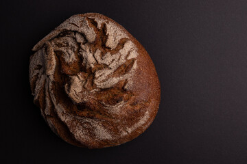 fresh rye bread isolated on black background, top view