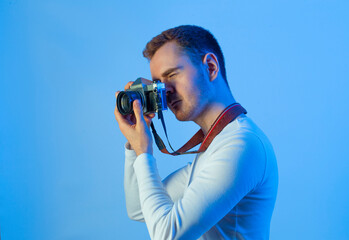 Contemporary young man posing in various poses in studio.Futuristic neon lighting.Taking pictures...