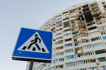 Chernihiv Ukraine 2022: Blue sign of a pedestrian crossing against the background of a bombed-out...