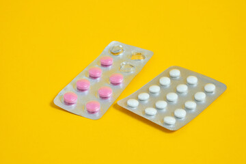 blister with pills on a yellow background close-up