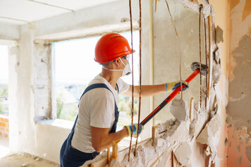 Repairer in boilersuit holding tools. Apartment repair and renovation concept.