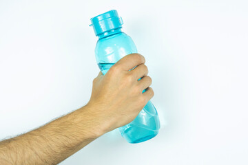 Hand holding a blue water bottle, isolated on white background, front view of bottle with water