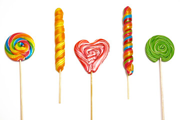 Multicolored lollipops are insulated on a white background. View from above. Copy space.