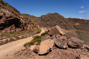 Panoramic view of of mountains with a dirt road in the Gata Cape Natural Park coast. Almería, Andalucía, Spain.
