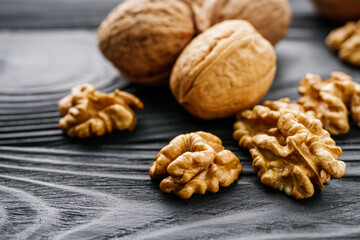 dried walnuts on a black rustic wooden background