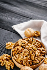 dried walnuts on a black rustic wooden background