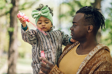 African american father spending time with his daughter in the park