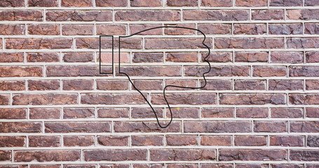 Image of glowing neon thumb down icon on brick wall