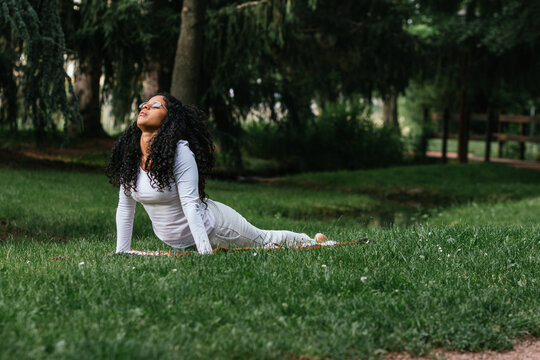 young Hispanic woman practicing yoga outdoors