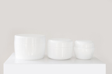set of clean white jar of moisturizer on a pedestal
