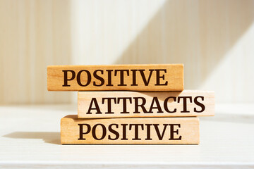Wooden blocks with words 'Positive Attracts Positive'.