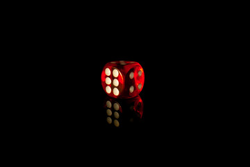 Red square dice on a black isolated background. Dice for playing craps or poker close up....
